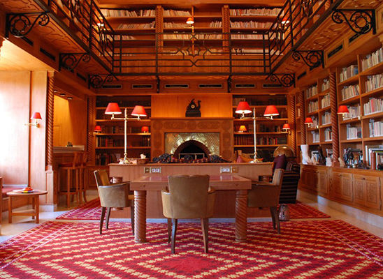 Salle à manger et cheminée pour cette pièce entourée de bibliothèques de livres d’art