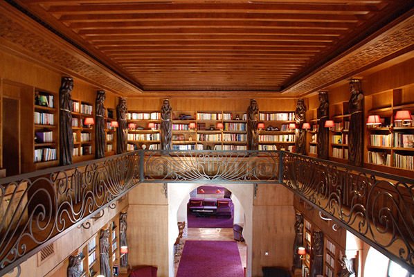 Grande bibliothèque avec coursive proposant un ensemble de romans et de livres d’histoire